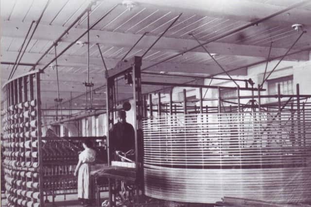 The scene inside a typical linen mill in the early 20th century, more than a century into the industrial revolution