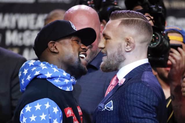 Boxer Floyd Mayweather Jr., left, and mixed martial arts fighter Conor McGregor exchange words