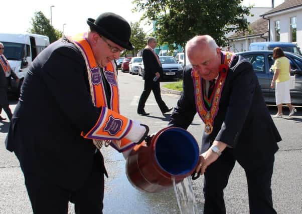 Worshipful District Master Neil Cousins and Co Down Grand Master Sam Walker pour Boyne Water across the road before the Kilkeel brethren commenced their march to Annalong.