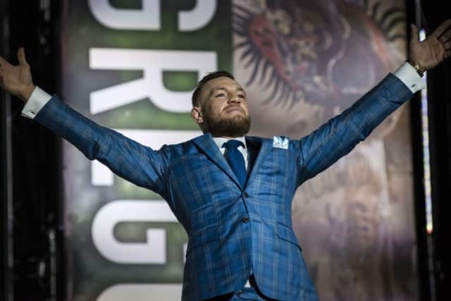 Conor McGregor gestures to the crowd during a promotional stop with Floyd Mayweather in Toronto