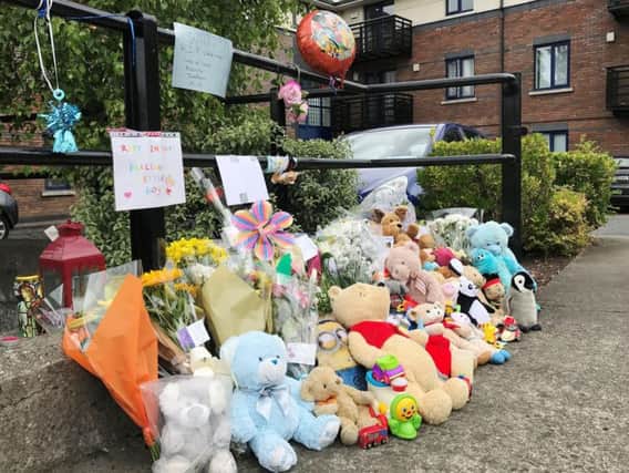 Flowers and teddy bears are left by the gates of the Riverside apartment complex in Kimmage, Dublin where three-year-old boy Omar Omran was found dead on Monday
