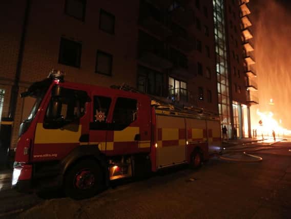 Fire officers at the apartment block beside the Sandy Row bonfire in south Belfast.