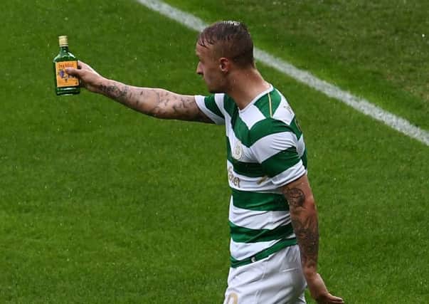 Celtic striker Leigh Griffiths shows the referee one of the items thrown on to the Windsor Park pitch last week in Belfast, an incident which has led to UEFA sanctions imposed on Linfield. Pic by Pacemaker.