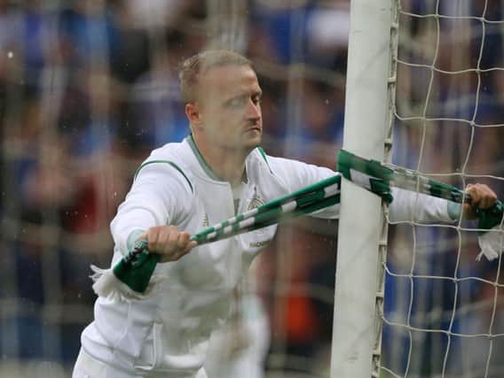 Leigh Griffiths ties a Celtic scarf to the post on the goal in front of the Kop at Windsor Park