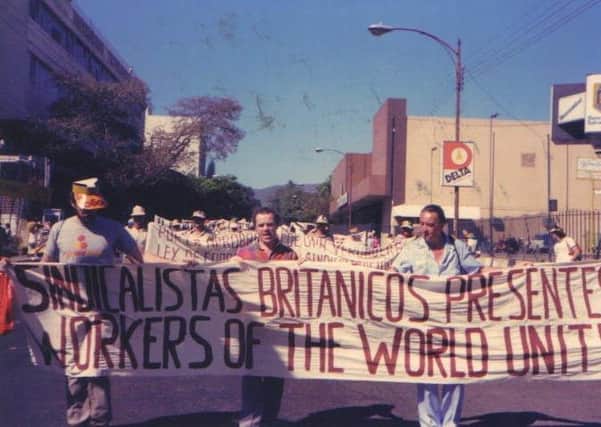Picture shows Chris Hudson, in the middle of the front banner, and tade unionists (names unknown), marching in San Salvador, El Salvador. Hudson (now Rev Hudson) recalls the man on the left of the picture (face obscured) to be Jeremy Corbyn, because he recalls him putting on the hat. Sent in by Chris Hudson