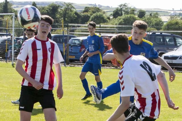 Aileach's Conor Clifford clears his line despite the close attention of two Tristar players during their under-16 Hughes Insurance Foyle Cup game
