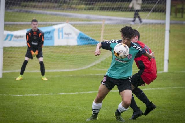 Derry City striker Finian O'Donnell attempts to turn his marker to get a shot on goal during the game against Tobermore