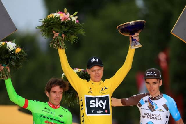 Team Sky's Chris Froome (centre) celebrates victory on the podium next to second place Cannondale's Rigoberto Uran (left) and third place AG2R La Mondiale's Romain Bardet (right). Photo: Adam Davy/PA Wire.