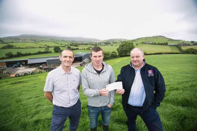Kevin Henry from CAFRE (left) and Eoin Donnelly, Specialist Agri-Advisor at First Trust Bank (right) are pictured presenting young farmer Joe Mulligan with a cheque for Â¬1,000 euros. Joe has been named runner-up in the AIB / Teagasc All-Ireland 'Best Farm Business Plan' competition and is the first farmer from Northern Ireland to win a top award in the final.