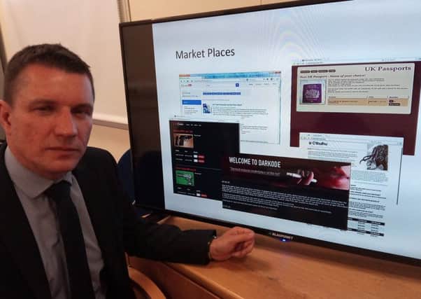 DCI Dougie Grant, head of the PSNI Cybercrime unit, with images from a range of dark web sites which sell guns, drugs and even contract killings.