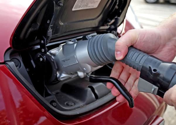 An electric or hybrid car is charged from a charging point