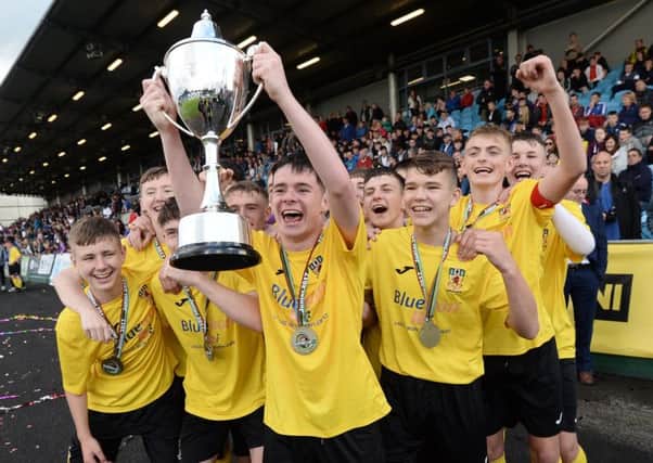 County Antrim's Junior players hold aloft the SuperCupNI trophy after victory over GPS Bayern. Pic by Pacemaker.