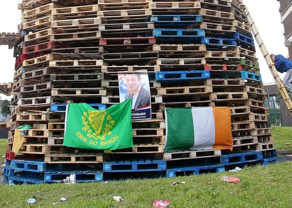 A bonfire in the nationalist New Lodge estate in north Belfast, with a poster of former UUP MP Danny Kinahan, with eyes crossed out and a line drawn around his neck