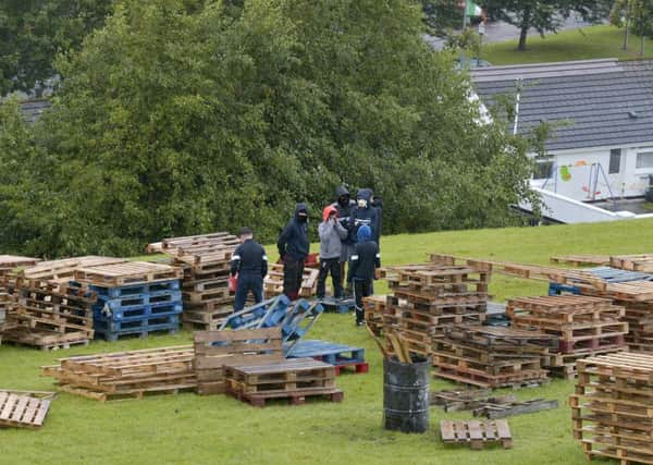 Children, with their faces hidden, pictured constructing the controversial Bogside bonfire.