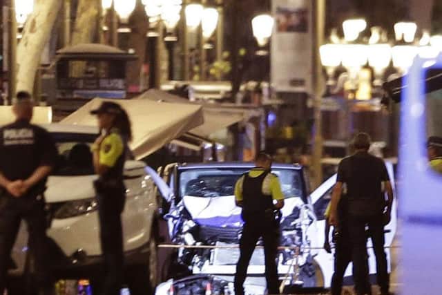 Police officers stand next to the van involved on an attack in Las Ramblas