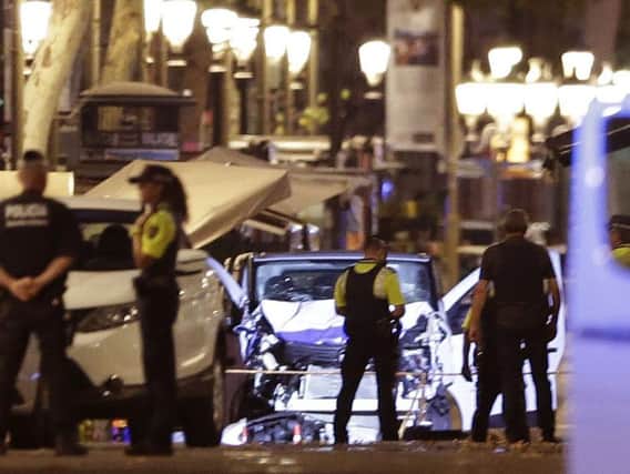 Police officers stand next to the van involved on an attack in Las Ramblas