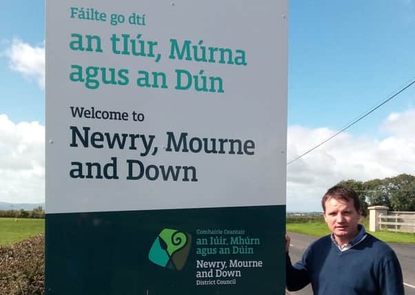 UUP Rathfriland councillor Glenn Barr at one of the Newry Mourne and Down District Council boundary signs around the town which has been repeatedly vandalised and replaced.