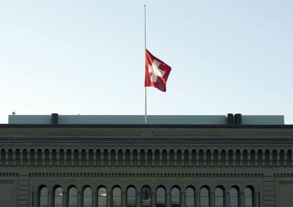 A Swiss flag above the government building in Bern, the federal city in a country with religious and ethnic differences, but that is stable and operates under a canton system