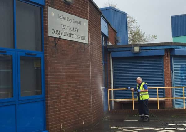 A Belfast City Council employee washes racist graffiti off the wall at  Inverary Community Centre in east Belfast