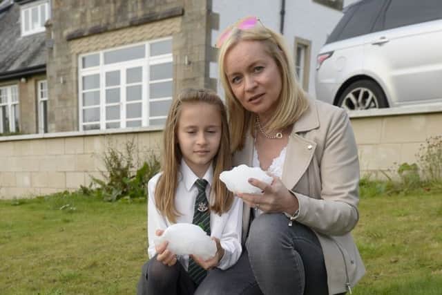 Lyndsey Helliwell and her daughter Elise in their garden in Busby, Glasgow, Scotland, where a large block of ice fell out of the sky