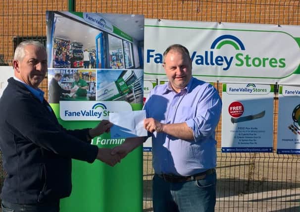 Store Manager of the Fane Valley Dungannon store Trevor Nesbitt handing over a prize voucher to Stephen Redmond