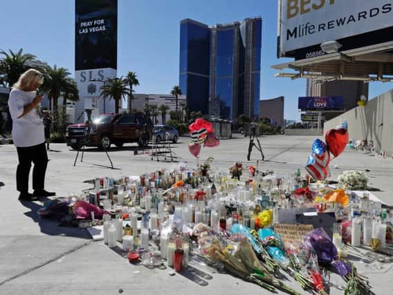 A woman looks over a makeshift memorial site on Las Vegas Boulevard