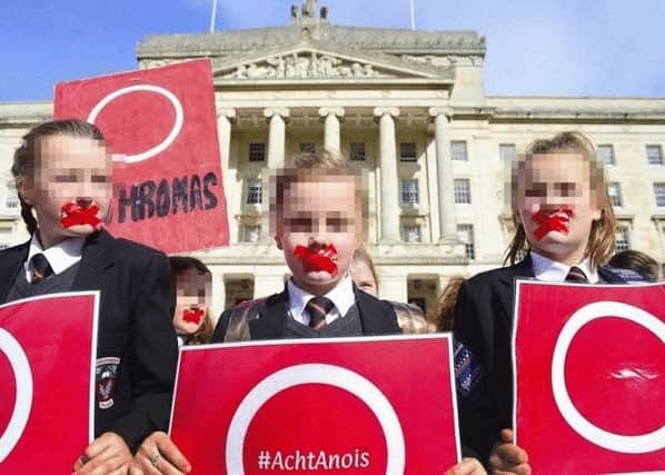Children with their mouths taped were accompanied by activists and Sinn Fein politicians at the Irish language protest at Stormont on September 28