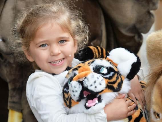 Harriet Ostime, 3, plays with Tyler the Tiger during the Hamleys Christmas toy showcase at Hamleys, London