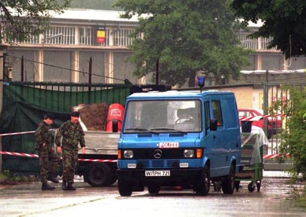 In this June 29, 1996 file photo, British soldiers walk to a police van that partly hides a pickup truck in front of a side entrance to Quebec barracks after a mortar attack
