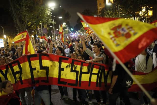 Anti-independence supporters shout slogans and wave Spanish flags as they march against the unilateral declaration of independence approved earlier by the Catalan parliament in downtown Barcelona Friday, Oct. 27, 2017.  Catalan Republic.(AP Photo/Francisco Seco)