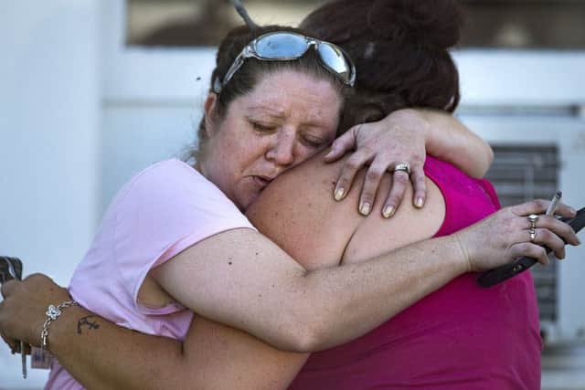 Carrie Matula embraces a woman after a fatal shooting at the First Baptist Church in Sutherland Springs, Texas, on Sunday, Nov. 5, 2017. Matula said she heard the shooting from the gas station where she works a block away