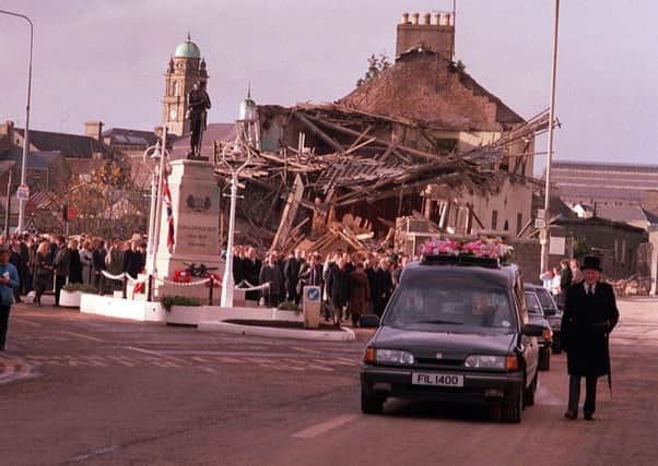 The funeral cortetge of an Enniskillen bomb victim passes the scene of the explosion at the town's cenotaph in November 1987.
