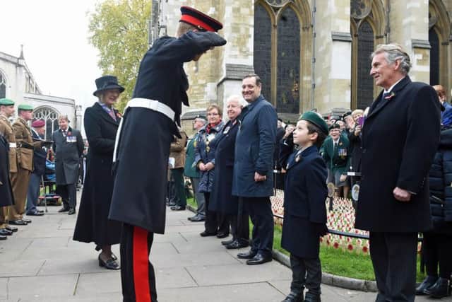 Prince Harry salutes to a child at Westminster Abbey's Field of Remembrance where he honoured the fallen ahead of Armistice Day