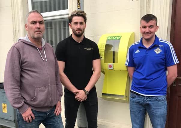 Keith Scott, Marc Carson and Alexander McCartan pictured in front of the empty defibrillator cabinet at Meeting Street.