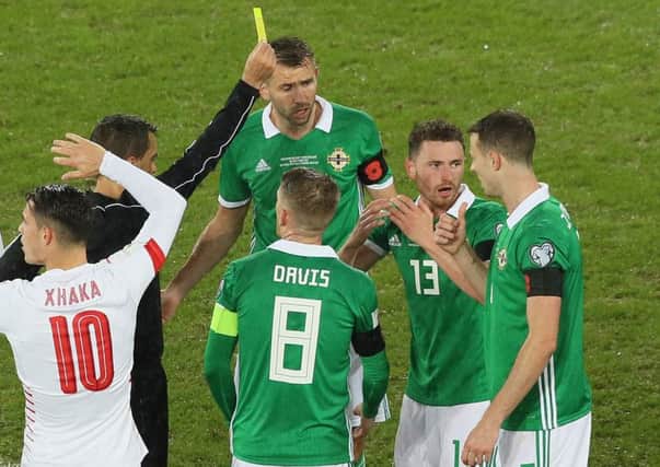 Referee Ovidiu Hategan gives Northern Ireland's Corry Evans a yellow card after making his controversial penalty decision during the 1-0 defeat to Switzerland in the World Cup qualifier at Windsor Park
