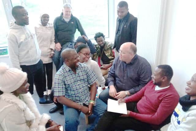 Alumni and supporters of the Fields of Life schools in Uganda laugh with Rev Willie Nixon, centre right, and Keith Mutabazi, in the red sweater, at Drumbeg church hall on their recent visit to Northern Ireland. Pic by Ben Lowry