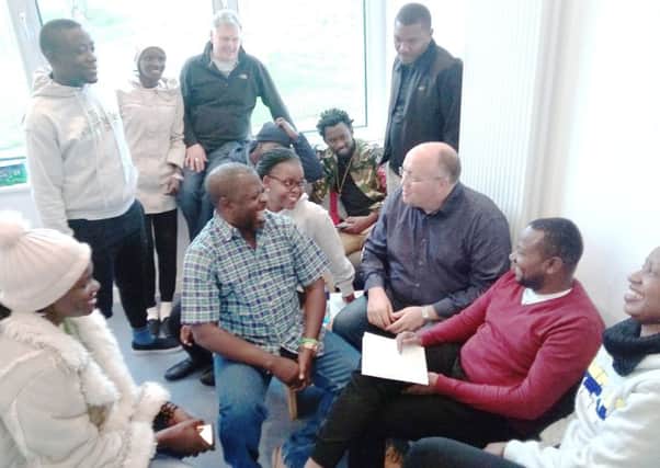 Alumni and supporters of the Fields of Life schools in Uganda laugh with Rev Willie Nixon, centre right, and Keith Mutabazi, in the red sweater, at Drumbeg church hall on their recent visit to Northern Ireland.  Pic by Ben Lowry